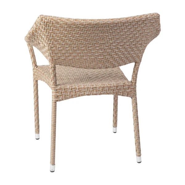 Back view of natural rattan patio dining chair with ergonomic contour and weather-resistant steel frame.