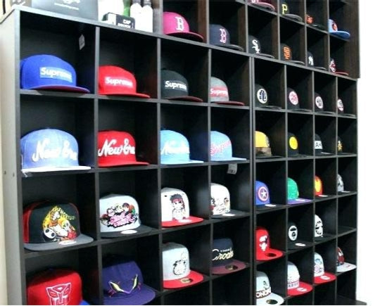 Hat display bin unit in a smooth Formica finish with uniform color and multiple open cubbies for merchandising hats.”