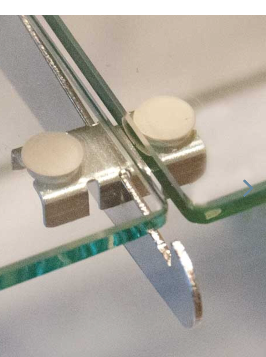 Close-up detail of the shelf rest’s rubber bumpers and satin finish, highlighting the notched design used for secure shelf placement.