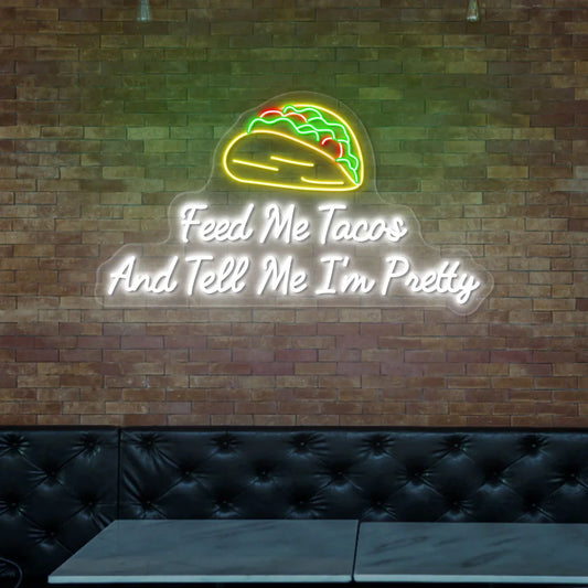 Feed Me Tacos and Tell Me I'm Pretty Neon Sign glowing in bright LED colors, perfect wall light for kitchens, bars, or taco shops.