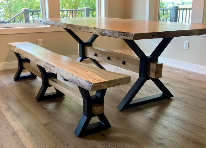 Three-quarter angled view of heavy-duty farmhouse style steel table legs with 1.5 x 3 inch tubing, large mounting plate, 4 x 4 inch center opening for wood beam installation, shown with adjustable leveling feet