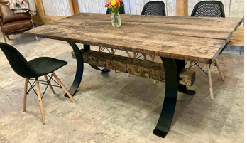 Side profile of the curved timber beam steel table leg showing the 1/2-inch thick mild steel construction, industrial curved silhouette, and flat black powder-coated finish designed for heavy commercial use