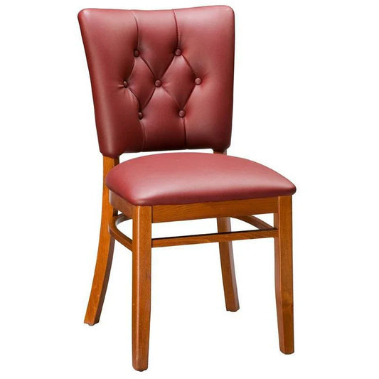 Drake upholstered beech wood dining chair in walnut finish with cream vinyl seat and back, featuring decorative nail trim detailing. Custom wood finishes and upholstery colors available. Made in the USA for restaurants and hospitality interiors.