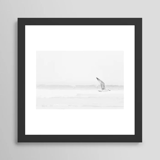 Minimal black and white seagull ocean photography art print in black wood frame – modern coastal wall decor by Ingrid Beddoes