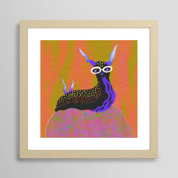 Sea Slug art print by Blindthesun in light maple frame highlighting soft wood grain and contemporary coastal style