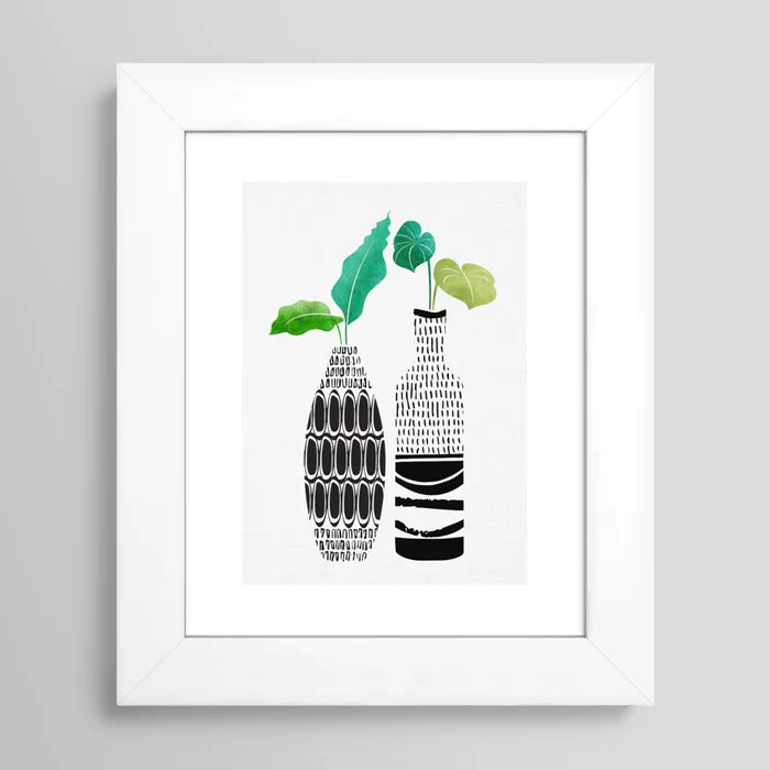 Botanical wall art print in white frame featuring tribal vase pattern and greenery