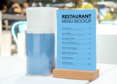Wood and acrylic tabletop menu holder with clear double-sided display panel and natural wood base on restaurant table.